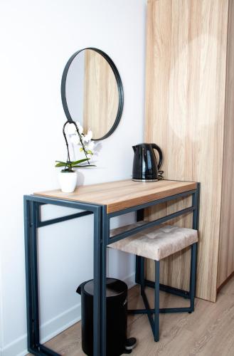 a desk with a mirror and a stool at Орбелус in Bansko