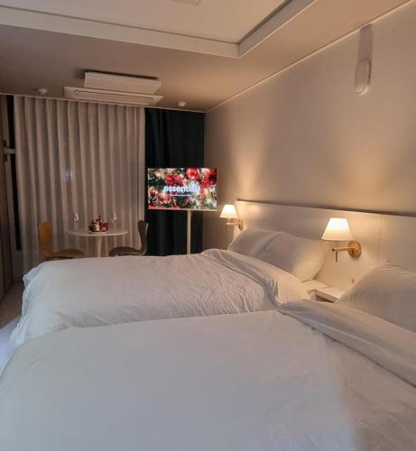 a hotel room with two beds and a television at Daegu StarB&B DSR Hotel mia Guestroom in Daegu