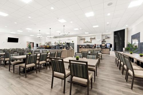 Un restaurante con mesas y sillas y una cafetería. en Best Western Plus Concordville Hotel, en Concordville