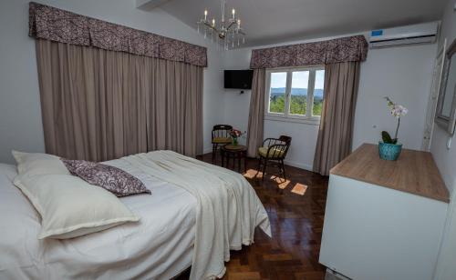 a bedroom with a bed and a table and a window at La Santa Hotel Boutique in Mendiolaza