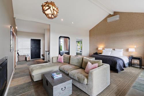 a living room with a couch and a bed at Woodhouse Mountain Lodge in Warkworth