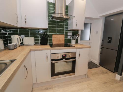 a kitchen with white cabinets and a stove top oven at Bryn Tawel in Betws-y-coed