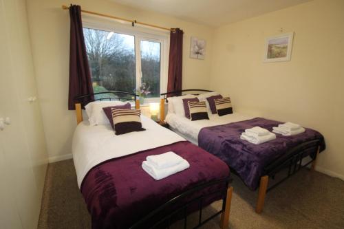 zwei Einzelbetten in einem Zimmer mit Fenster in der Unterkunft Keswick House Chesterfield by Smart Corporate Stays in Newbold