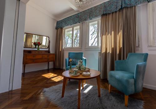 a living room with two blue chairs and a table at La Santa Hotel Boutique in Mendiolaza