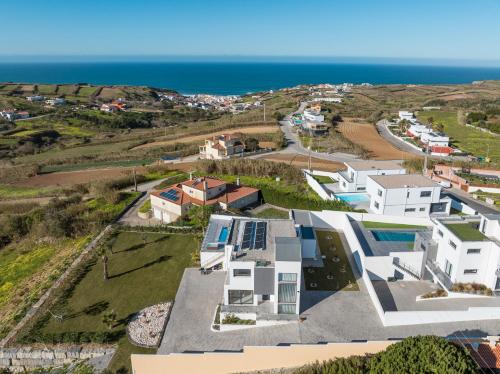 Una vista aérea de una casa con el océano al fondo. en Villa Gold with ocean view, jacuzzi and private pool, en Ribamar