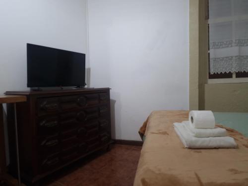 a bedroom with a television on a dresser with towels at Truz truz2 in Porto