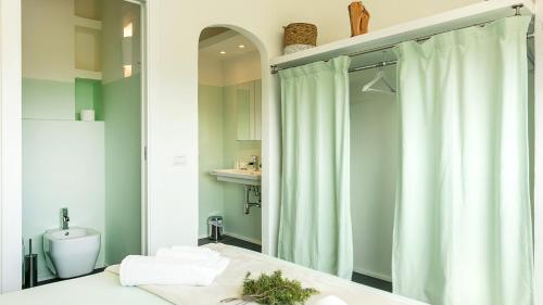 bagno con tenda per la doccia e servizi igienici di Sardegna è - Beach Apartments a Olbia