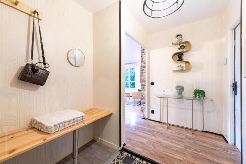 a hallway with a bench and a table in a room at Family Travel Paris 4 in Bussy-Saint-Georges
