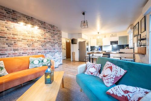 - un salon avec un canapé bleu et un mur en briques dans l'établissement Family Travel Paris 4, à Bussy-Saint-Georges