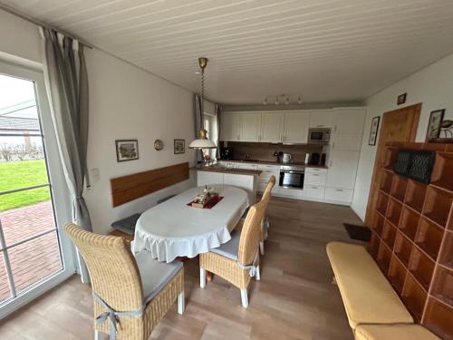 a kitchen and dining room with a table and chairs at Ferienhaus Ankerglück in Friedrichskoog-Spitz