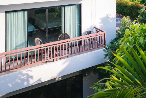 a balcony of a building with chairs on it at Wilacha Chiang Rai in Chiang Rai