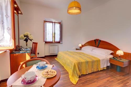 a hotel room with a bed and a table with a table at Affittacamere Villa Gigli in Sirolo