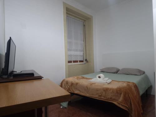 Cette chambre comprend deux lits, un bureau et une télévision. dans l'établissement Truz truz2, à Porto