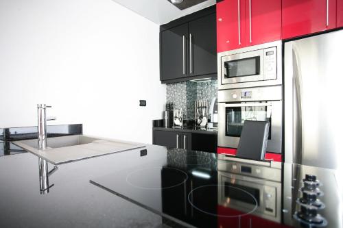a kitchen with red cabinets and a counter top at Absolute Bangla Suites in Patong Beach