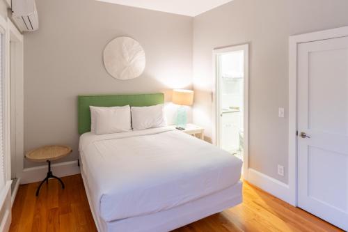 a bedroom with a white bed with a green headboard at The Newport Lofts - 194 Thames Street in Newport