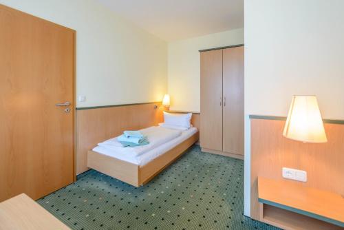 a hotel room with a bed and a lamp at Am Weststrand Aparthotel Kühlungsborn in Kühlungsborn
