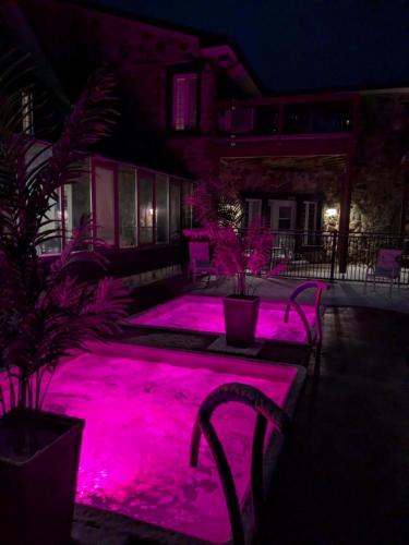 a pool with pink lights in a yard at night at Condo Hotel Au pied du Mont Orford in Orford