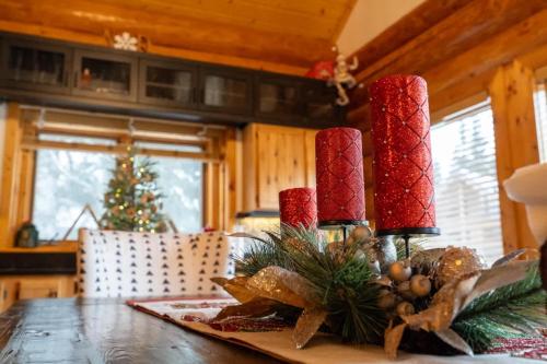 a dining room table with red candles and a christmas tree at Luxury Family Cabin at Summit West in Snoqualmie Pass
