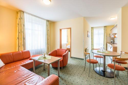 a hotel room with a couch and chairs and a table at Am Weststrand Aparthotel Kühlungsborn in Kühlungsborn