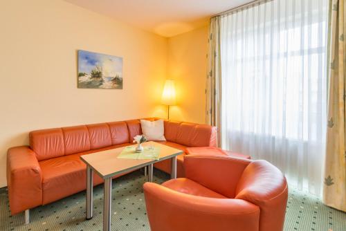 a living room with a couch and a table at Am Weststrand Aparthotel Kühlungsborn in Kühlungsborn