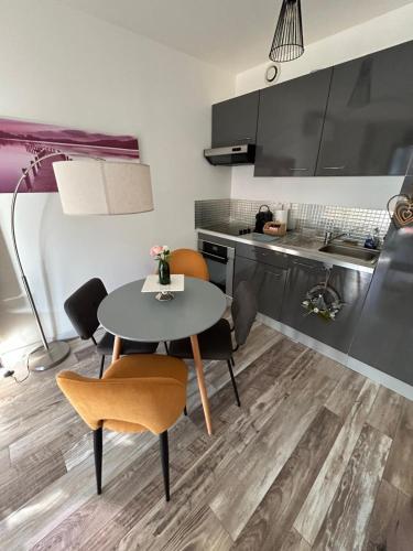 une cuisine et une salle à manger avec une table et des chaises dans l'établissement F2 Hypercentre Terrasse Talleyrand, à Reims