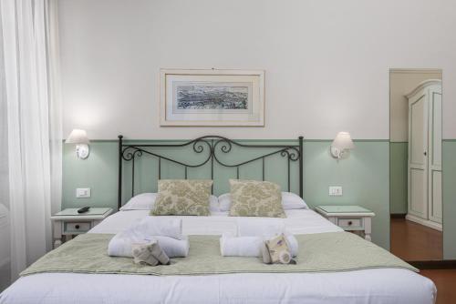 a bedroom with a large bed with white sheets and pillows at UNYCA - Domus22 - San Giovanni in Florence