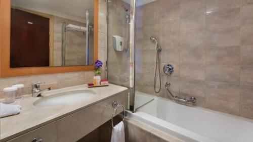 a bathroom with a tub and a sink and a shower at Crowne Plaza Haifa by IHG in Haifa