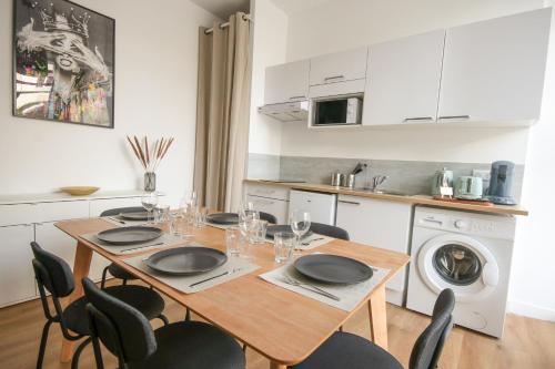 une salle à manger avec une table et des chaises et une cuisine dans l'établissement Le Pop Art - Parking Privé, à Angoulême