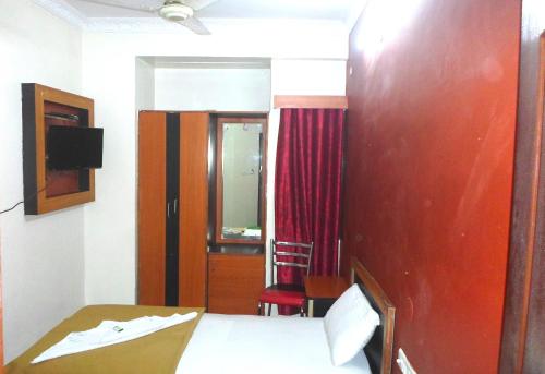 a hotel room with a bed and a red wall at King Residency in Bengaluru