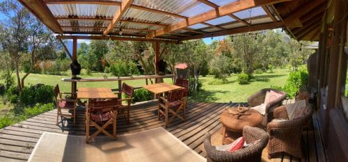 a wooden deck with a table and chairs on it at casona ser deluxe in Pucón