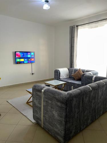 a living room with a couch and a tv at Snowhaven One bedroom accomodation Kitengela in Kitengela 