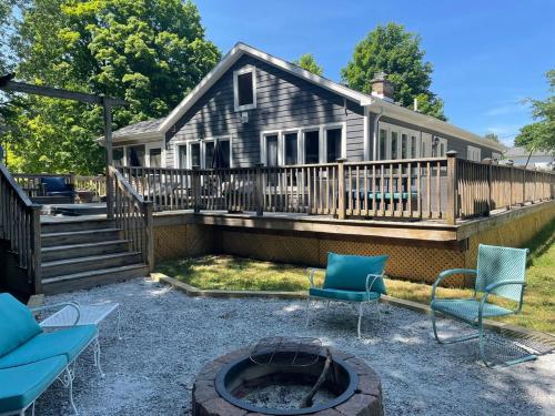 a house with a deck with chairs and a fire pit at In Union Pier! By Beach with 5 bedrooms, jacuzzi, yard in Union Pier