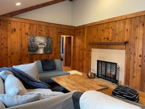 a living room with wooden walls and a fireplace at In Union Pier! By Beach with 5 bedrooms, jacuzzi, yard in Union Pier