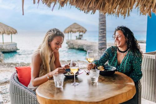 克拉伦代克Delfins Residences的两个女人坐在桌子上,戴着酒杯