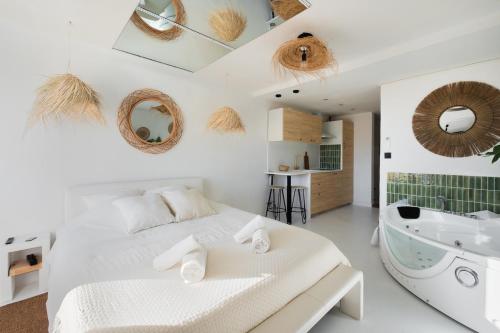 a bedroom with a bed and a tub and a sink at Suite Casa Azul in Mauguio