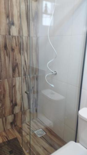 a shower with a glass door in a bathroom at Chalés do Caminho - Aconchego in Santa Rita do Rio Abaixo