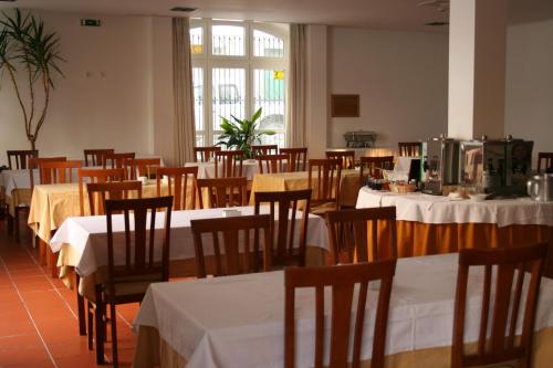 a dining room with tables and chairs with white table cloth at Hotel Solar dos Pachecos in Lamego
