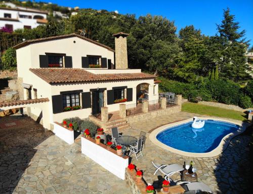 a house with a swimming pool in front of it at Villa Costa Brava in Calonge