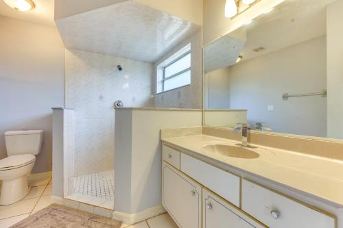 a bathroom with a sink and a toilet and a mirror at Pet-Friendly Palm Coast Home 8 Mi to Beach! in Palm Coast