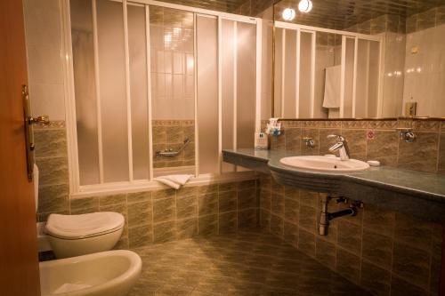 a bathroom with a toilet and a sink and a mirror at Hotel Sevlievo Plaza in Sevlievo