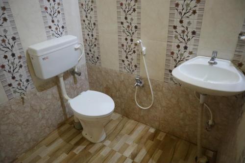 a bathroom with a toilet and a sink at Hotel Sahil Inn in Mandarmoni