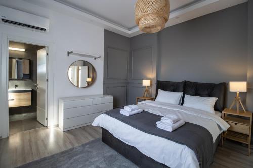 a bedroom with a large bed and a mirror at Luxury Two Bedroom Penthouse in Caesar Resort & SPA, Long Beach in Perivolia tou Trikomou