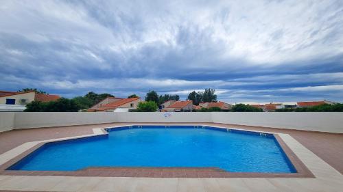 - une grande piscine bleue au-dessus d'une maison dans l'établissement Maisonnette familiale climatisée dans résidence avec piscine, à Vic-la-Gardiole