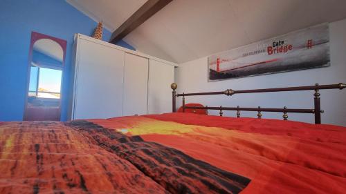 a bedroom with a bed with a colorful blanket at Maisonnette familiale climatisée dans résidence avec piscine in Vic-la-Gardiole