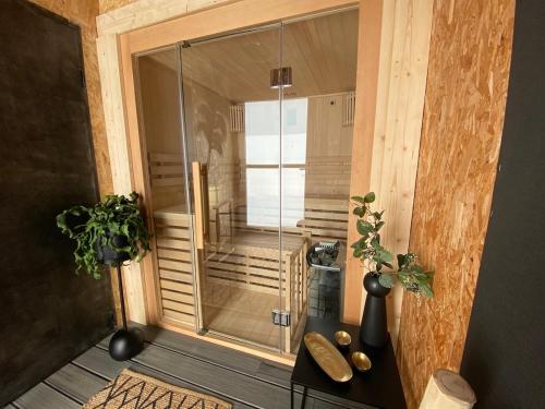 a glass shower in a room with a wooden floor at Villa de Rospico Les villas de Nevez in Névez