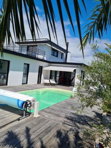 une maison avec une piscine devant une maison dans l'établissement Villa de Rospico Les villas de Nevez, à Névez