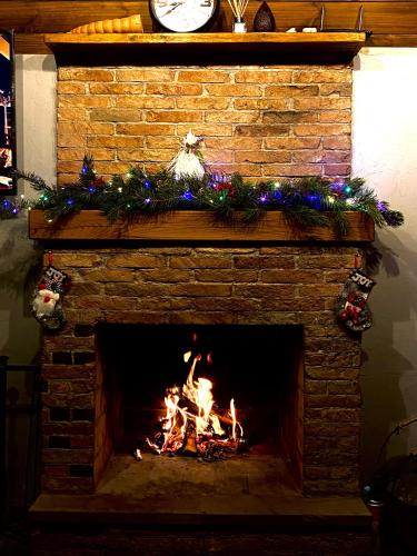 a brick fireplace with a fire in it at Deka Achkhoti in Stepantsminda