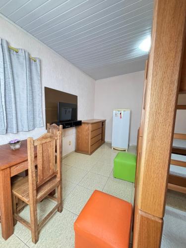 a room with a kitchen with a table and a refrigerator at Pousada Recanto dos Maximianos in Jarinu