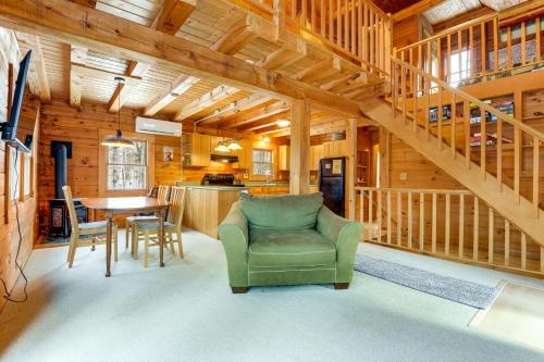 a living room with a green chair and a table at 2 Mi to Boat Ramp Log Cabin in New Hampshire in Washington