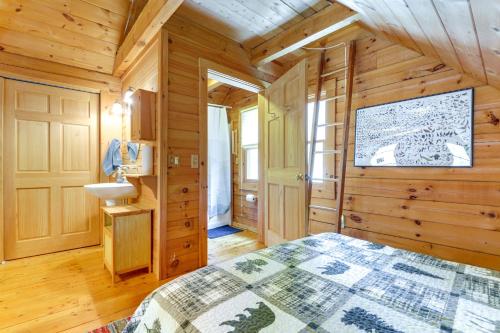 a log cabin bedroom with a bed and a sink at 2 Mi to Boat Ramp Log Cabin in New Hampshire in Washington